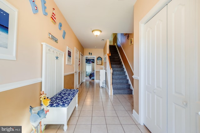 hallway with light tile patterned floors and stairs