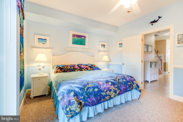 carpeted bedroom featuring tile patterned flooring, baseboards, and ceiling fan