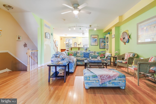 living room featuring a ceiling fan, wood-type flooring, and baseboards