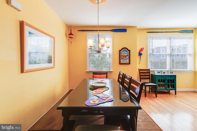 dining room with baseboards, wood finished floors, and a notable chandelier