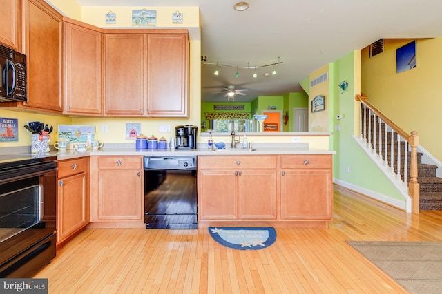 kitchen with black appliances, light wood-style floors, light countertops, and a sink