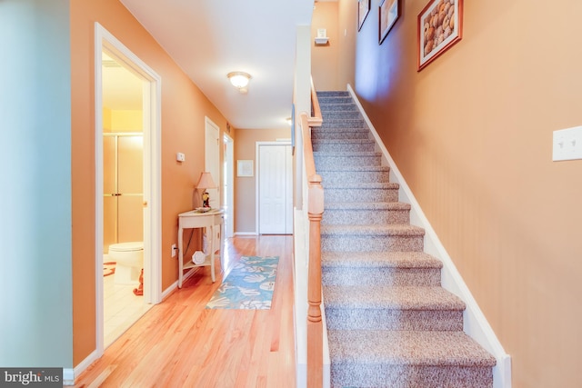 staircase with wood finished floors and baseboards