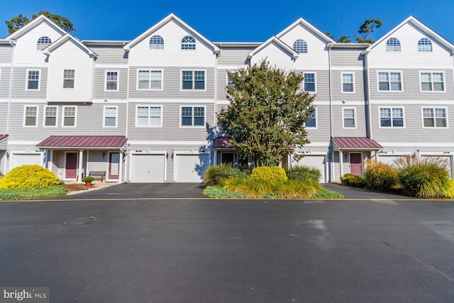 multi unit property featuring a garage, a residential view, and driveway