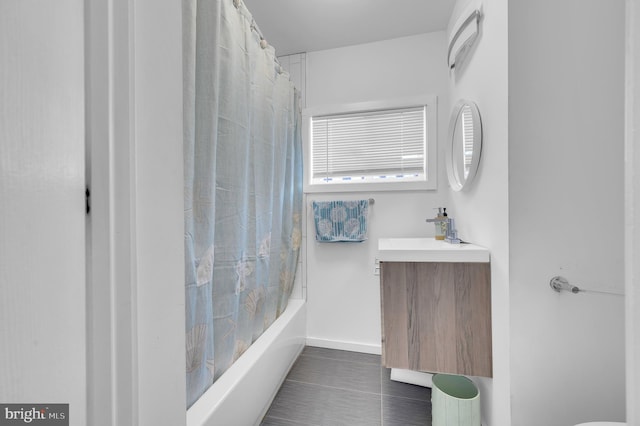 full bath featuring vanity, tile patterned floors, baseboards, and shower / bath combo