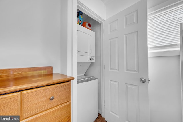 washroom featuring stacked washer / drying machine and laundry area