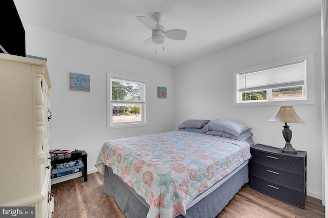 bedroom with wood finished floors, baseboards, and ceiling fan