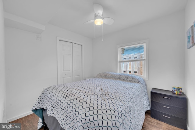 bedroom featuring a closet, baseboards, ceiling fan, and wood finished floors