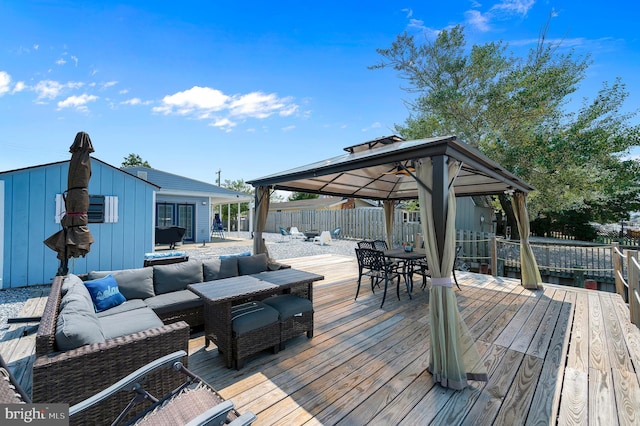 wooden deck featuring a gazebo, a fenced backyard, outdoor lounge area, and outdoor dining space