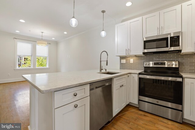 kitchen with white cabinets, light hardwood / wood-style flooring, stainless steel appliances, sink, and kitchen peninsula