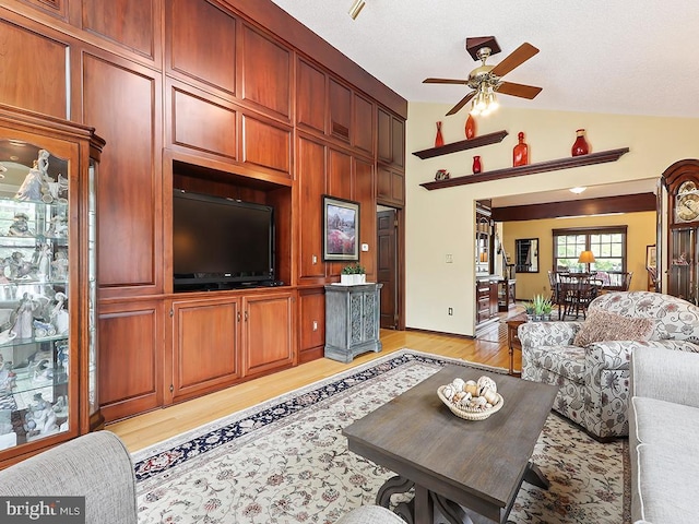 living room with light wood-type flooring, ceiling fan, and high vaulted ceiling