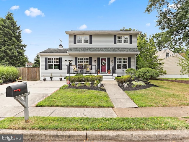 front facade with a front yard and covered porch