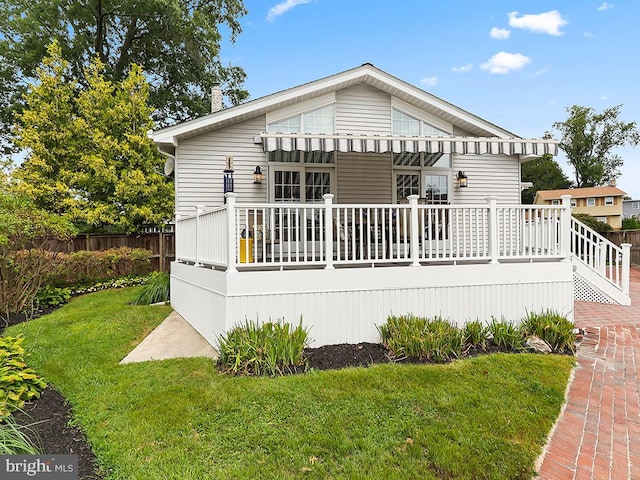 rear view of property with a lawn and a deck