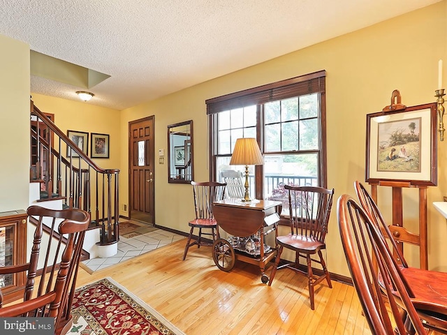 living area featuring a textured ceiling and light hardwood / wood-style flooring