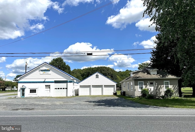 view of front of house with a garage and an outbuilding