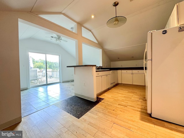 kitchen with decorative light fixtures, dark countertops, freestanding refrigerator, open floor plan, and white cabinetry