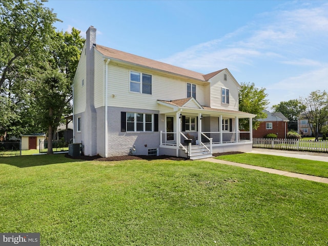 view of front facade featuring fence, covered porch, a front yard, brick siding, and a chimney