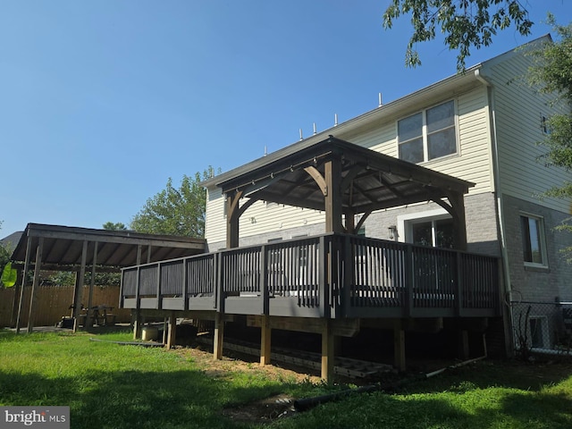 back of property with a deck, a lawn, and a gazebo