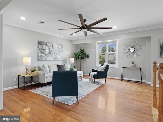 living area featuring baseboards, visible vents, recessed lighting, crown molding, and light wood-type flooring