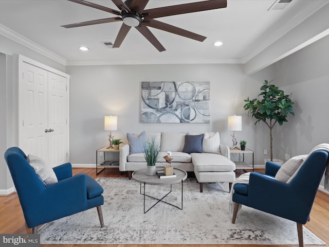 living room with hardwood / wood-style floors, ceiling fan, and ornamental molding