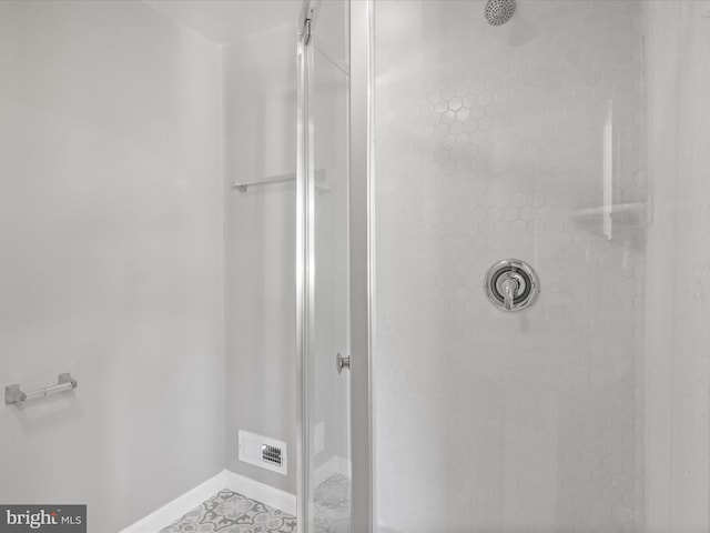 bathroom featuring tile patterned flooring and a tile shower