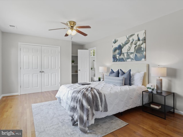 bedroom featuring visible vents, wood finished floors, a closet, baseboards, and ceiling fan