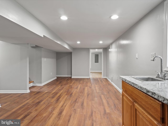 interior space featuring a sink, baseboards, wood finished floors, and recessed lighting