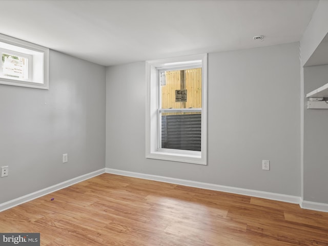 unfurnished room with baseboards and wood finished floors