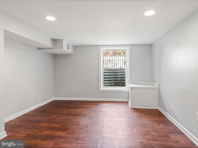 empty room with dark hardwood / wood-style flooring