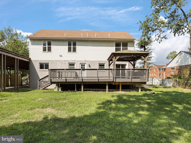 back of property with a lawn, a deck, and fence