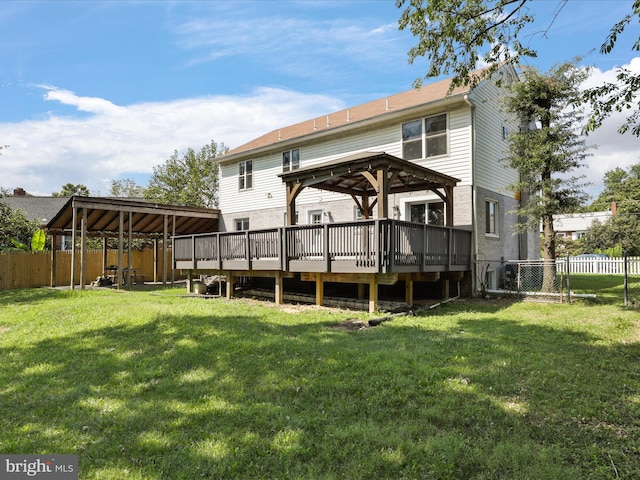 back of property featuring a gazebo, a lawn, fence, and a wooden deck