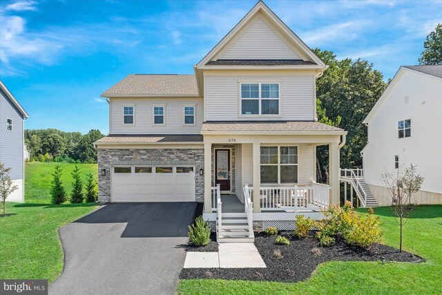 view of front facade with a garage, a front yard, and a porch