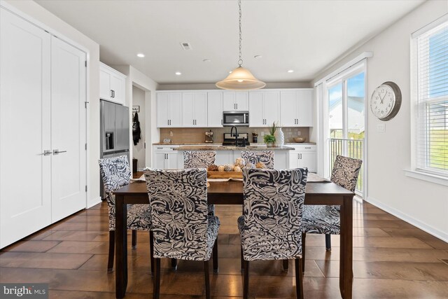 kitchen featuring white cabinets, dark wood-type flooring, decorative backsplash, and a healthy amount of sunlight