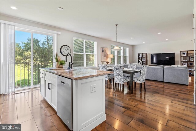 kitchen featuring white cabinets, plenty of natural light, an island with sink, and dishwasher