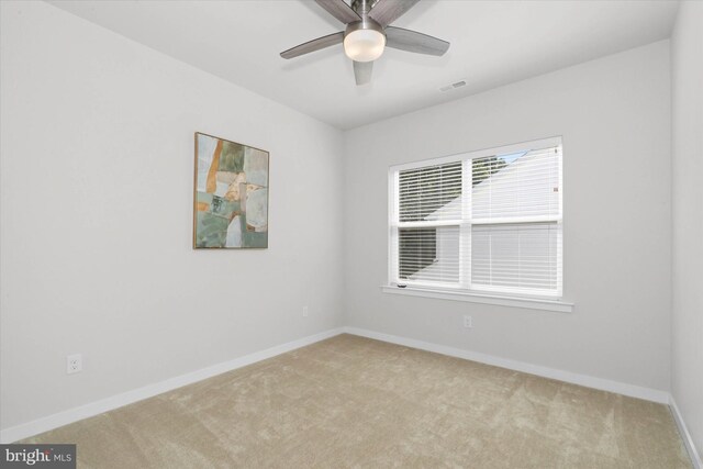 carpeted spare room with ceiling fan