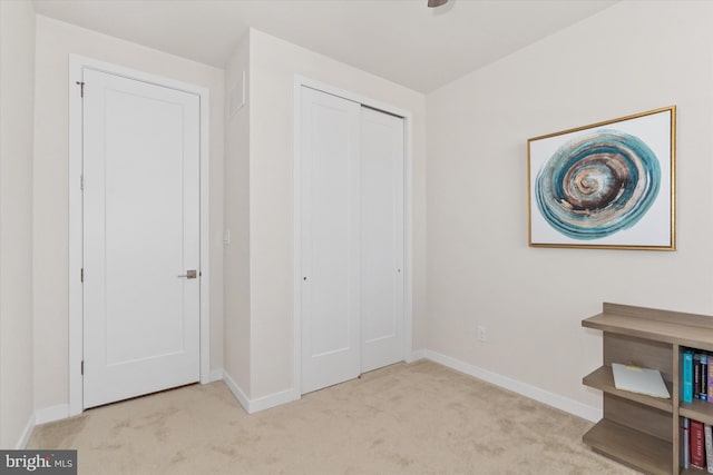 unfurnished bedroom with a closet and light carpet