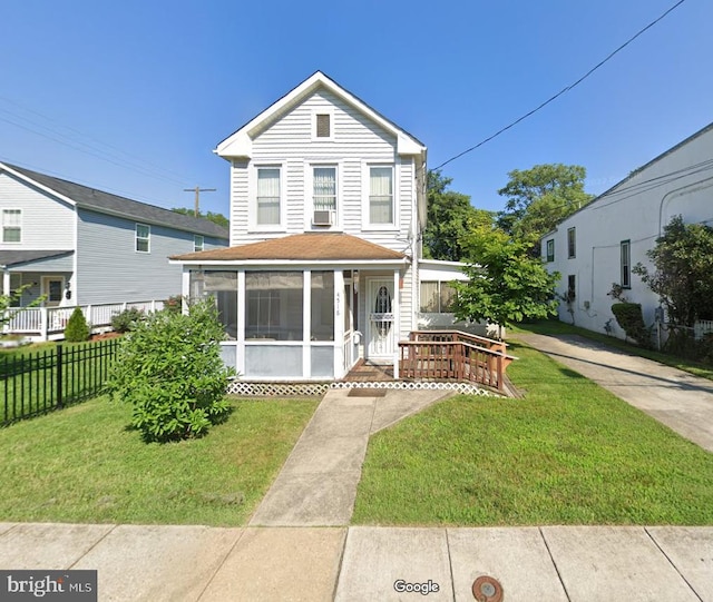 view of front of property with cooling unit, a front yard, and a sunroom