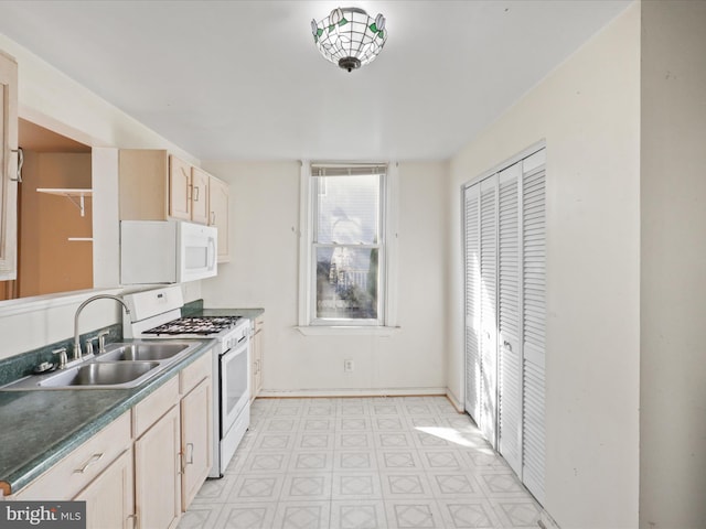 kitchen featuring sink, light brown cabinets, and white appliances