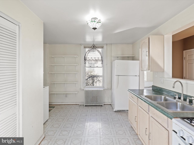 kitchen with light brown cabinetry, sink, white appliances, and radiator