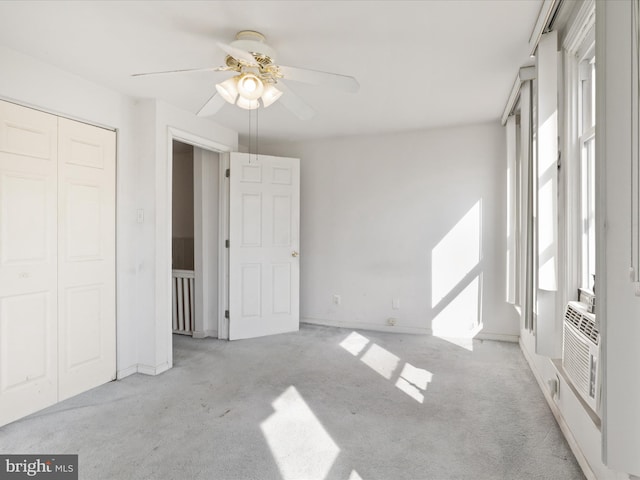 unfurnished bedroom featuring light carpet, a closet, and ceiling fan