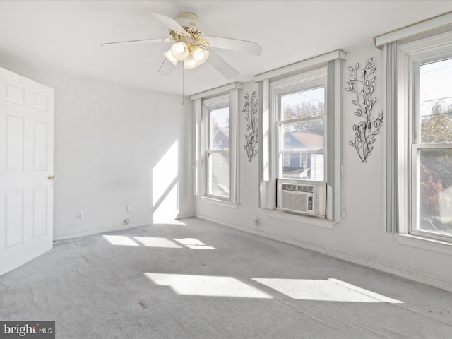 spare room with cooling unit, light colored carpet, and ceiling fan