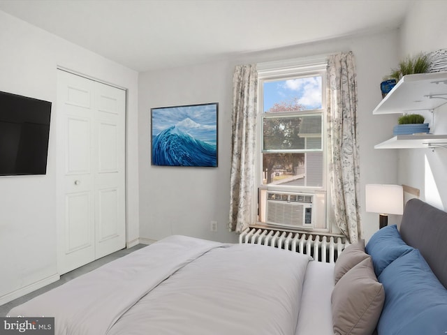 bedroom with radiator, a closet, and cooling unit