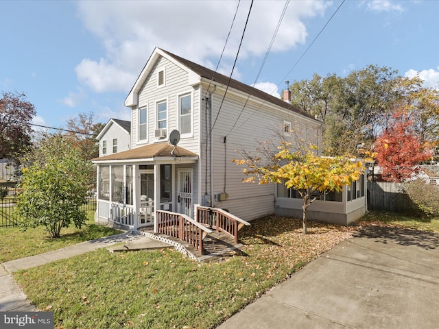 view of front of property featuring a sunroom and a front yard