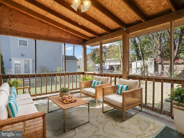 sunroom / solarium with vaulted ceiling with beams, plenty of natural light, and ceiling fan