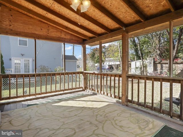 unfurnished sunroom with lofted ceiling with beams, ceiling fan, and plenty of natural light