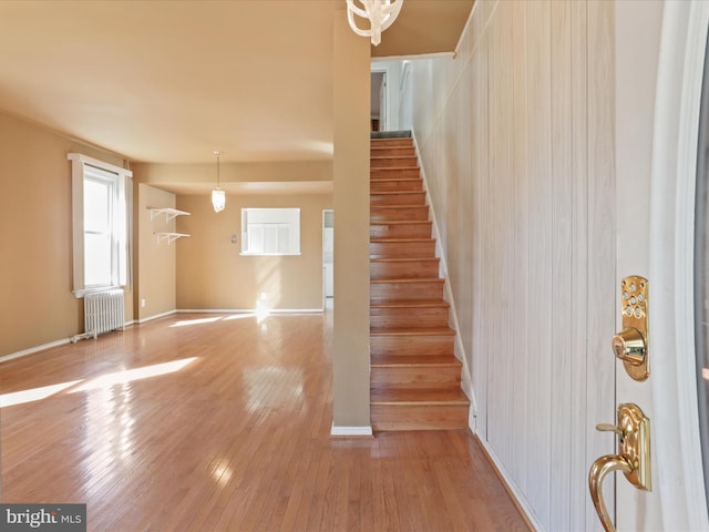 staircase featuring hardwood / wood-style floors and radiator