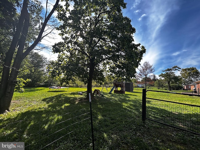 view of yard featuring fence and a playground