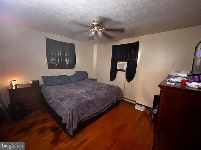 bedroom featuring dark wood-style floors, a baseboard heating unit, ceiling fan, and a textured ceiling