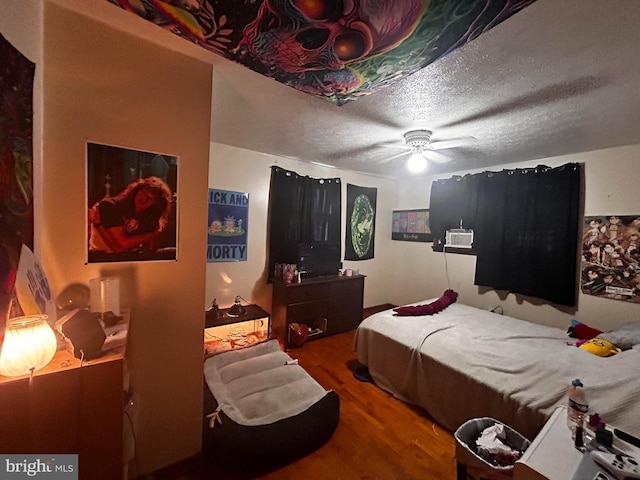 bedroom featuring a textured ceiling, a ceiling fan, and wood finished floors