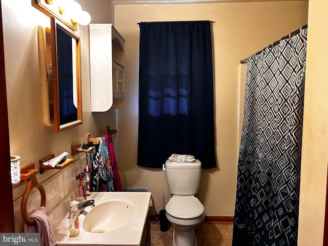 bathroom with baseboards, vanity, toilet, and tile patterned floors