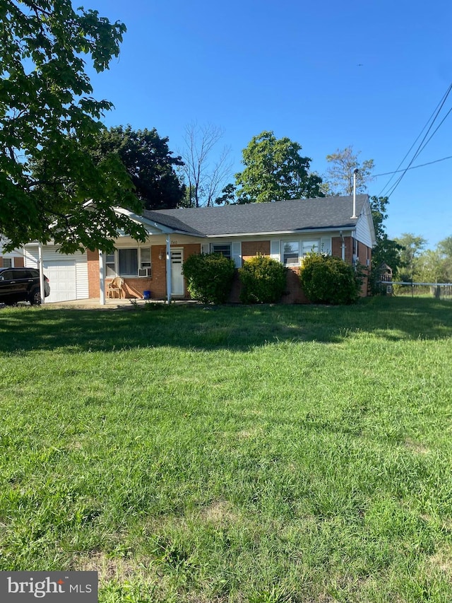 view of front of property with a front lawn, an attached garage, and brick siding